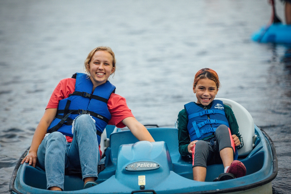 IMAGE: If you ever get the chance - counselor and camper in pedal boat